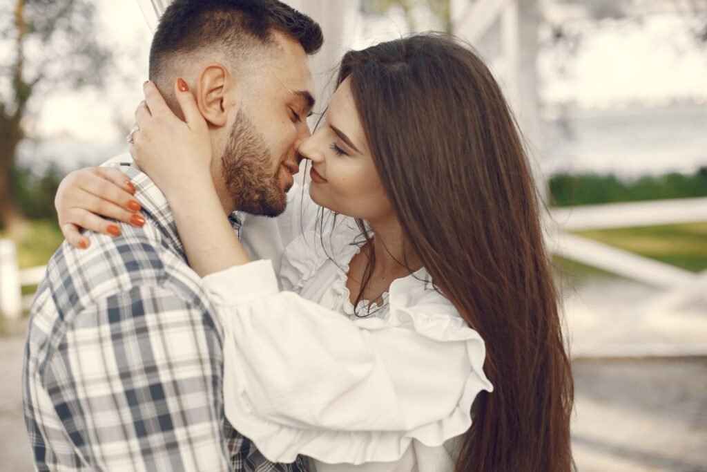 Couple sharing a tender moment outdoors with warm lighting, expressing love and connection.